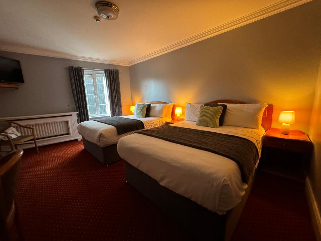 Postel nebo postele na pokoji v ubytování The Killarney Grand