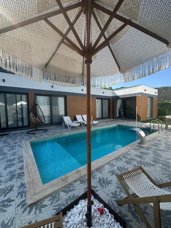 費特希耶的住宿－Villa Doğa 2，一个带大遮阳伞的游泳池和一个游泳池