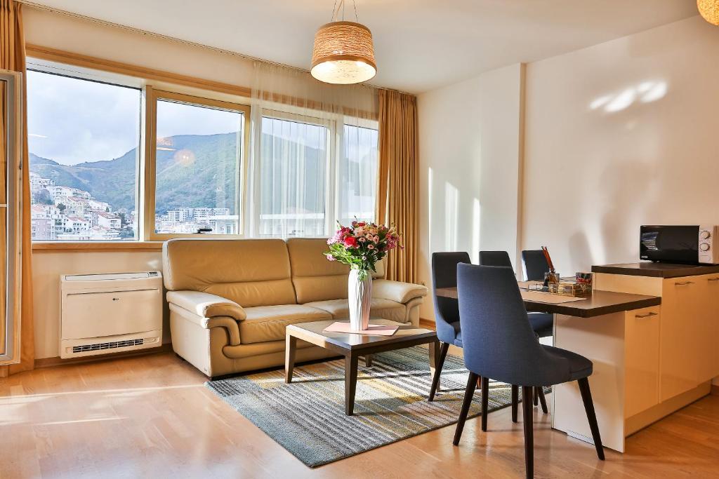 a living room with a couch and a table with chairs at Luxury Fontana Apartments in Budva