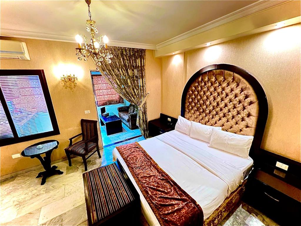 een hotelkamer met een groot bed en een bureau bij Queens Suite Hotel in Beiroet