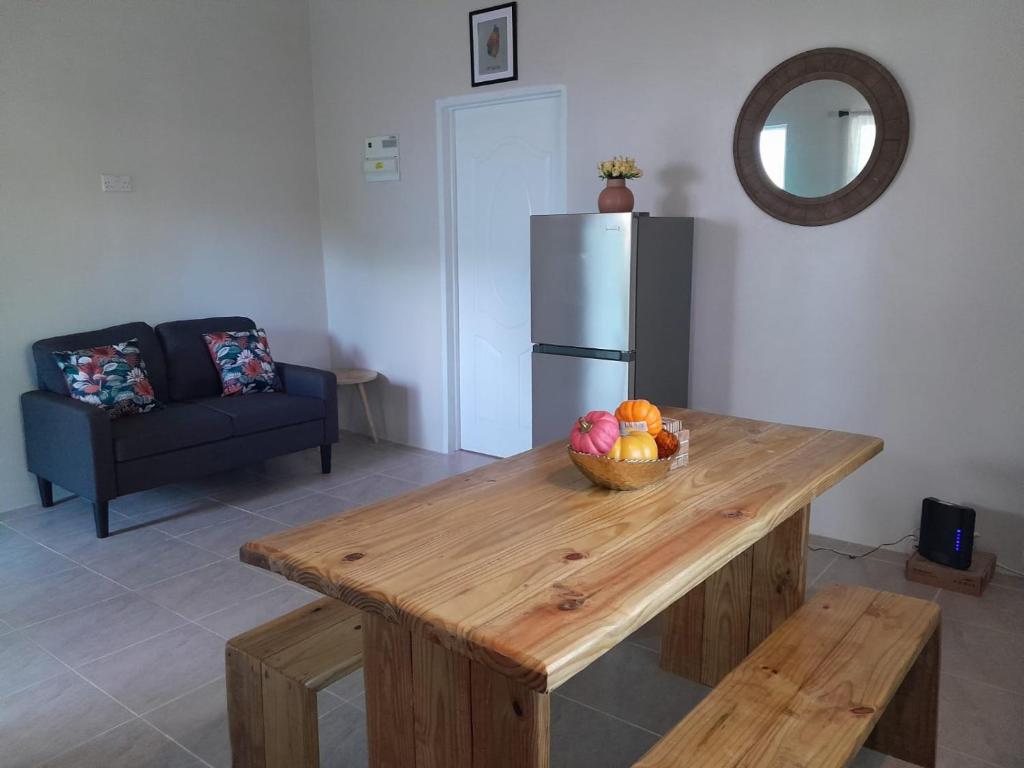 a kitchen with a table with a bowl of fruit on it at Vee's Country Apartments in Micoud