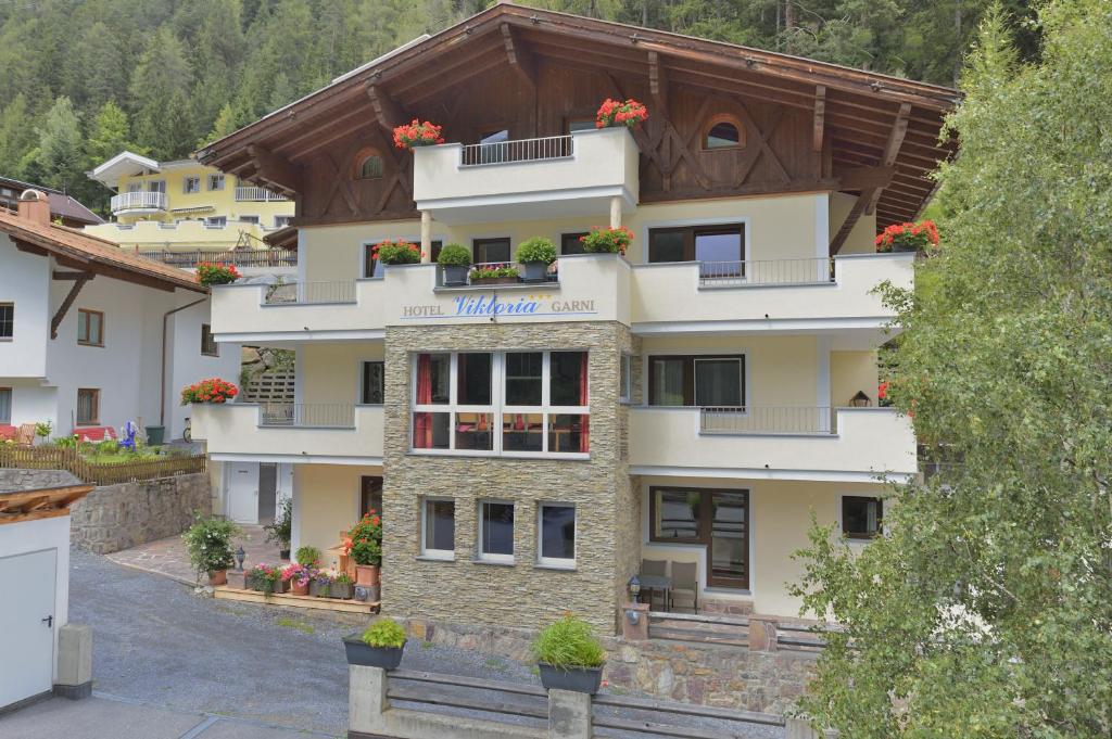 a building with flowers on the balconies of it at Hotel Garni Viktoria in Sankt Anton am Arlberg