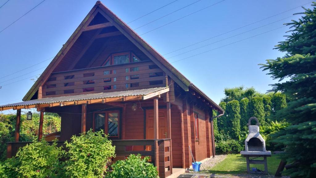 uma cabana de madeira com um telhado inclinado em Domek letniskowy OLEK em Ryn