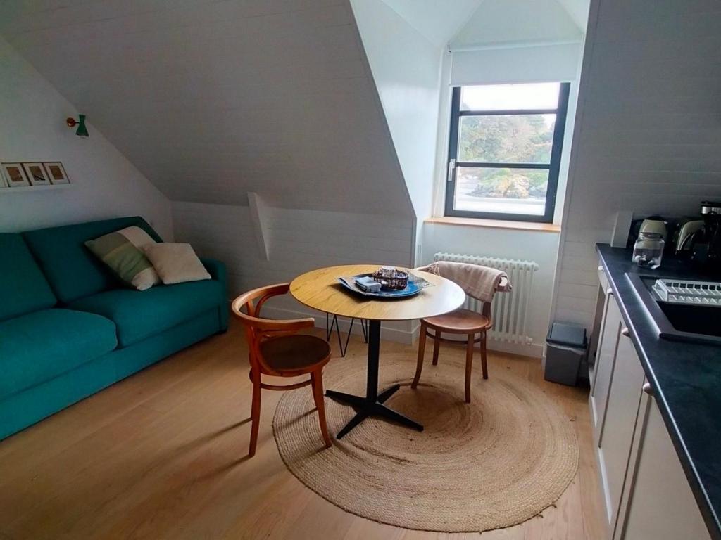 una pequeña sala de estar con mesa y sofá en Studio Sauzon, 1 pièce, 2 personnes - FR-1-418-189, en Sauzon
