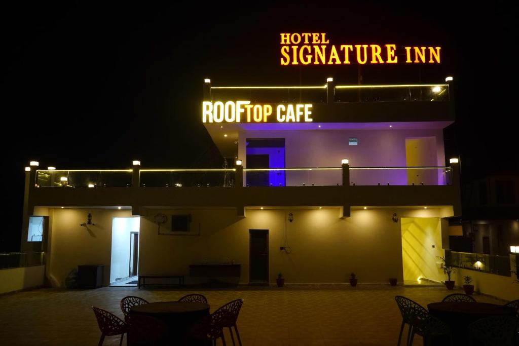 uma estalagem exclusiva do hotel à noite com um sinal de néon em HOTEL SIGNATURE INN em Ambikāpur