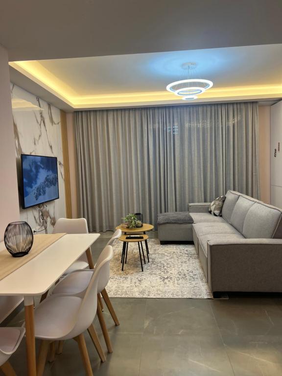 ein Wohnzimmer mit einem Sofa und einem Tisch in der Unterkunft CozyApartmens in Tirana