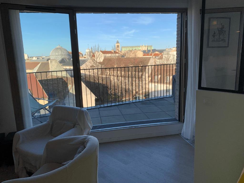 a room with two chairs and a balcony with a view at Whole apartment - Saint-Denis, France in Saint-Denis