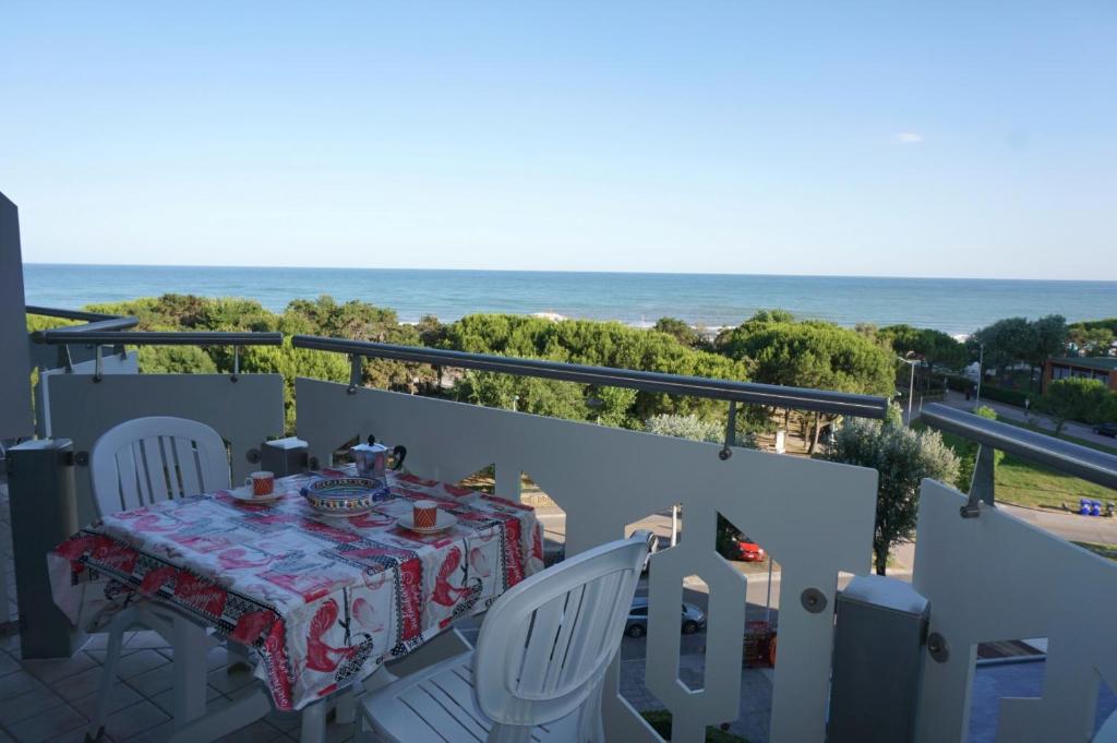 stół i krzesła na balkonie z widokiem na ocean w obiekcie Fresh and cozy seaside studio w mieście Porto Santa Margherita di Caorle