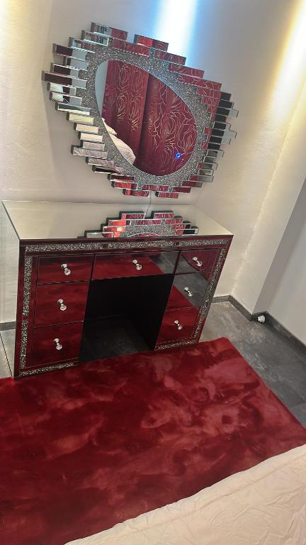 een rode dressoir met een spiegel aan de muur bij 1001 Nacht in Hagen