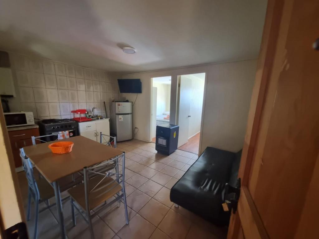 una pequeña cocina con una mesa y una silla. en Departamentos Arlenne, en Valdivia