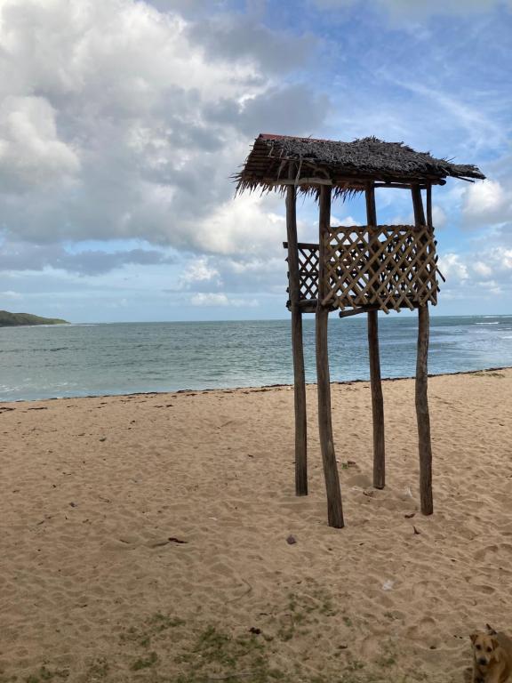 a wooden stand on a beach with the ocean at Emmasguesthouse in Paracale