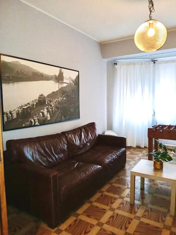 a living room with a leather couch and a painting at Segundo Antolín Yellow Door in Ponferrada
