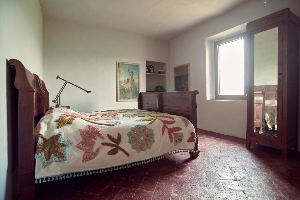 a bedroom with a bed with a comforter and a window at Cascina Mima - Monferrato in Quargnento