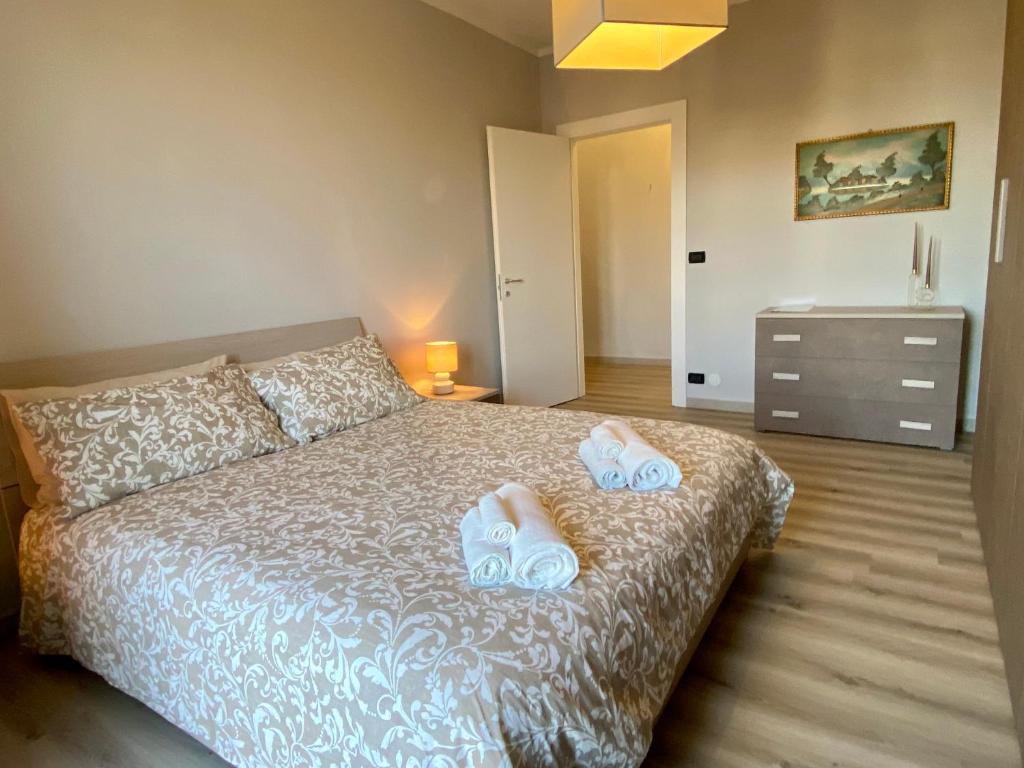 una camera da letto con un letto e due pantofole sopra di Elegante Appartamento Tre Amis -Free WiFi & Private Box a Centallo