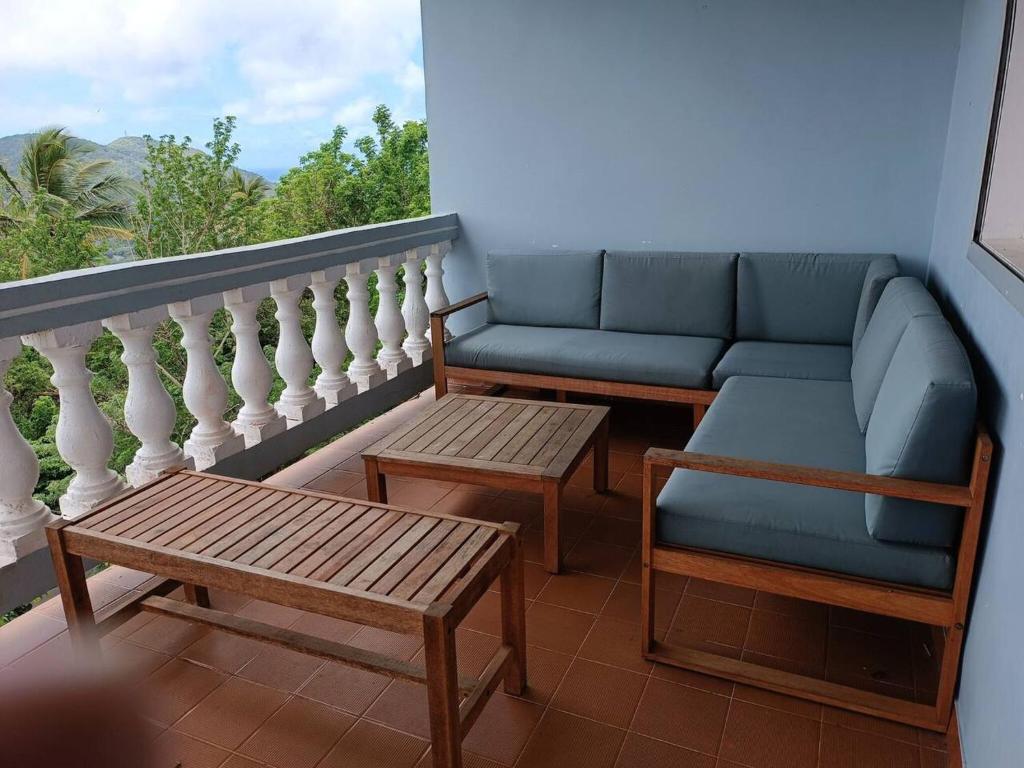 een balkon met een bank, een bank en een tafel bij Maison de 4 chambres avec jacuzzi terrasse et wifi a Riviere Pilote a 3 km de la plage in Rivière-Pilote