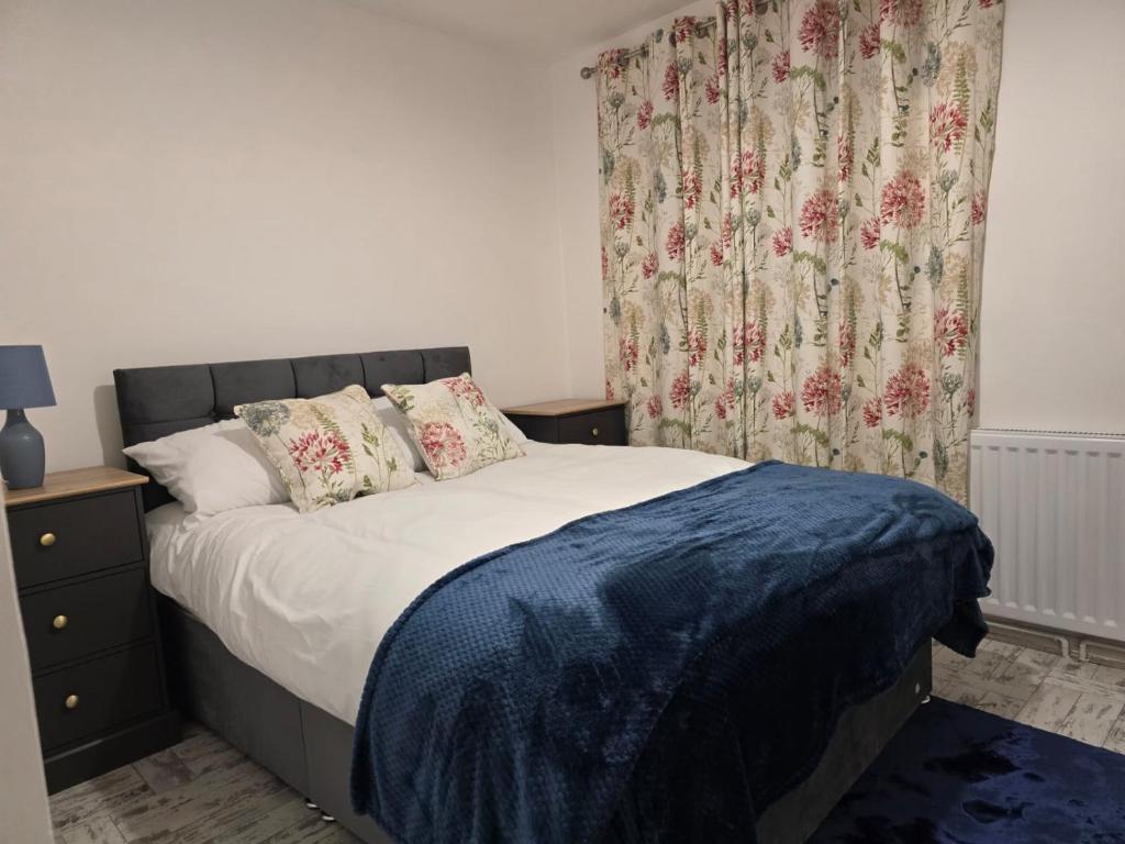a bedroom with a bed and a window with a curtain at Stylish 3 bedrooms in Bradwell