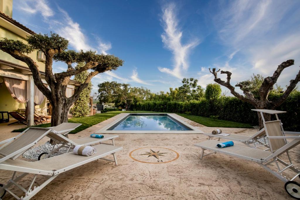- une piscine avec 2 chaises longues dans l'établissement Villa MERAVIGLIA, heated pool, 16 km from the sea, à Ascoli Piceno