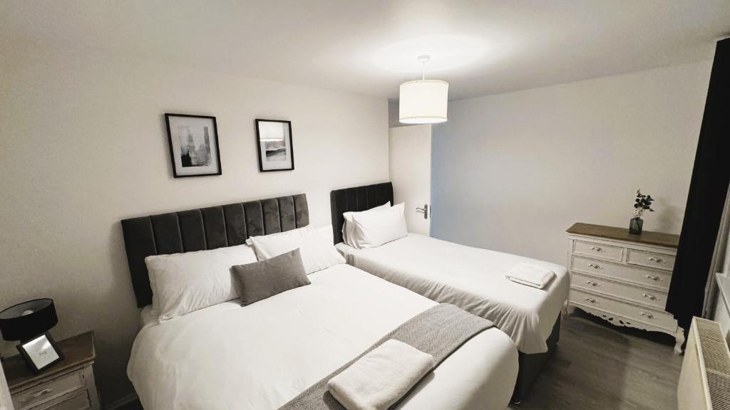 1 Schlafzimmer mit 2 Betten und einer Kommode in der Unterkunft Villa Retreat Birmingham in Birmingham