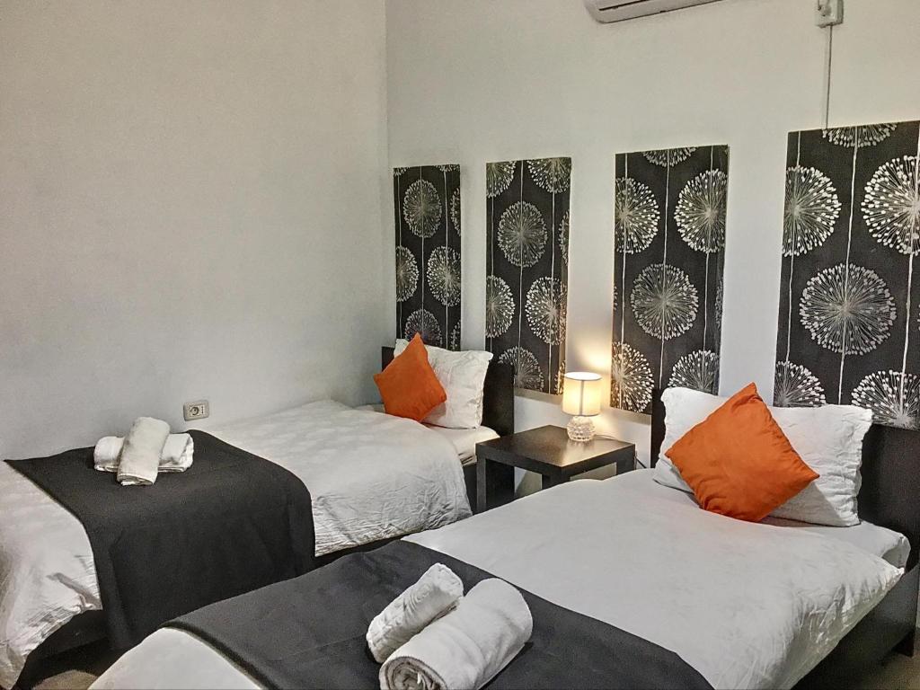 um quarto com 2 camas com almofadas laranja e branca em Casa Bozi em Utvin