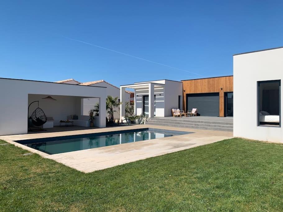 une maison avec une piscine dans une cour dans l'établissement Villa contemporaine avec piscine et grand jardin, à Bernis