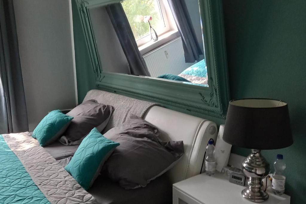 1 cama con almohadas y espejo en una habitación en Private Apartment Smoker, en Hannover