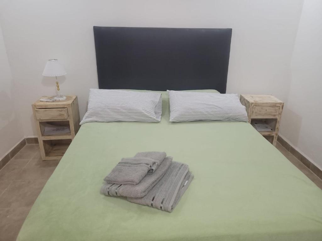 1 cama con manta y 2 mesitas de noche en Hermosa Casita paso patria III en Paso de la Patria