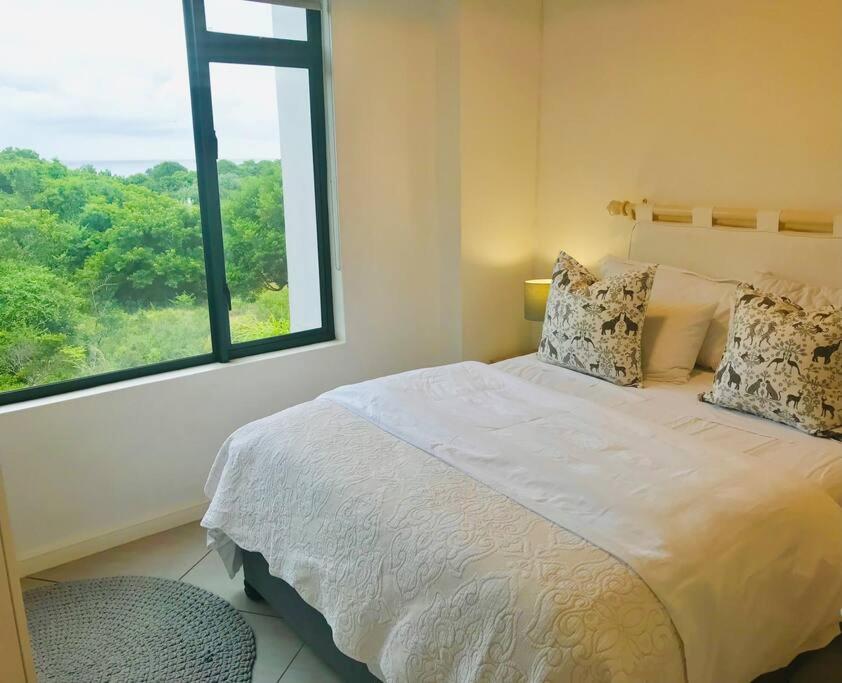 a bedroom with a large bed and a window at 1 bedroom apartment in Sibaya in Sibaya