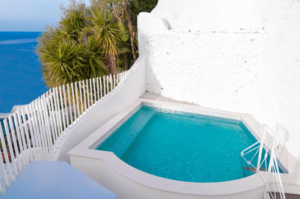 a swimming pool on the side of a white building at Villa Edlin in Praiano