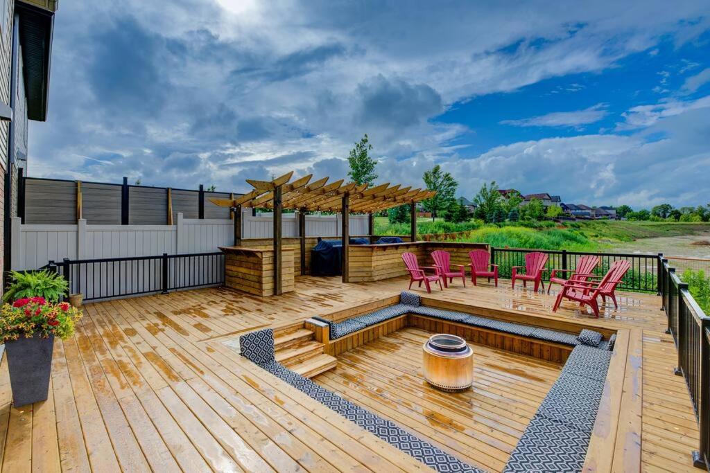 a wooden deck with chairs and a gazebo at Rivertrail Retreat in Kitchener