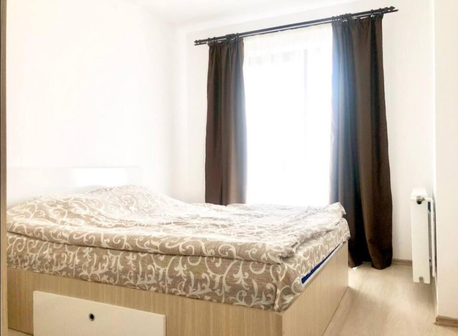 een bed in een kamer met een raam bij Cozzy Place in Târgovişte