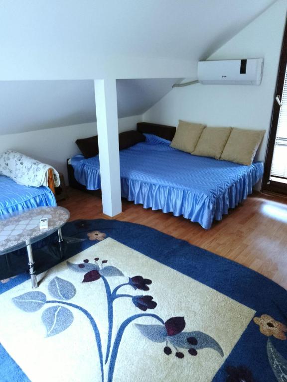 a room with two beds and a rug at DRAGICA Manastirska 10 in Ljubovija