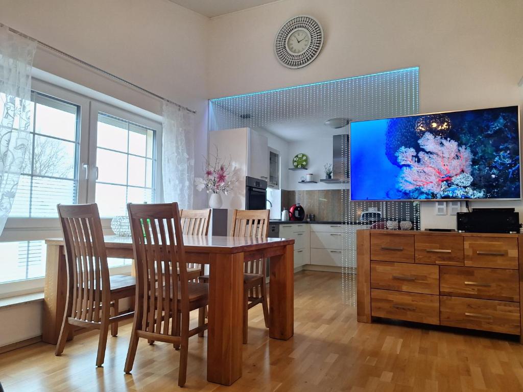 ein Esszimmer mit einem Tisch und einem Großbild-TV in der Unterkunft modern und gemütlich in Linden