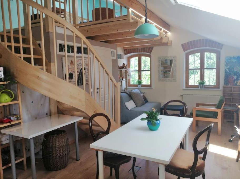 sala de estar con escalera, mesa y sillas en Atelieo beim Nussbaum en Ternitz