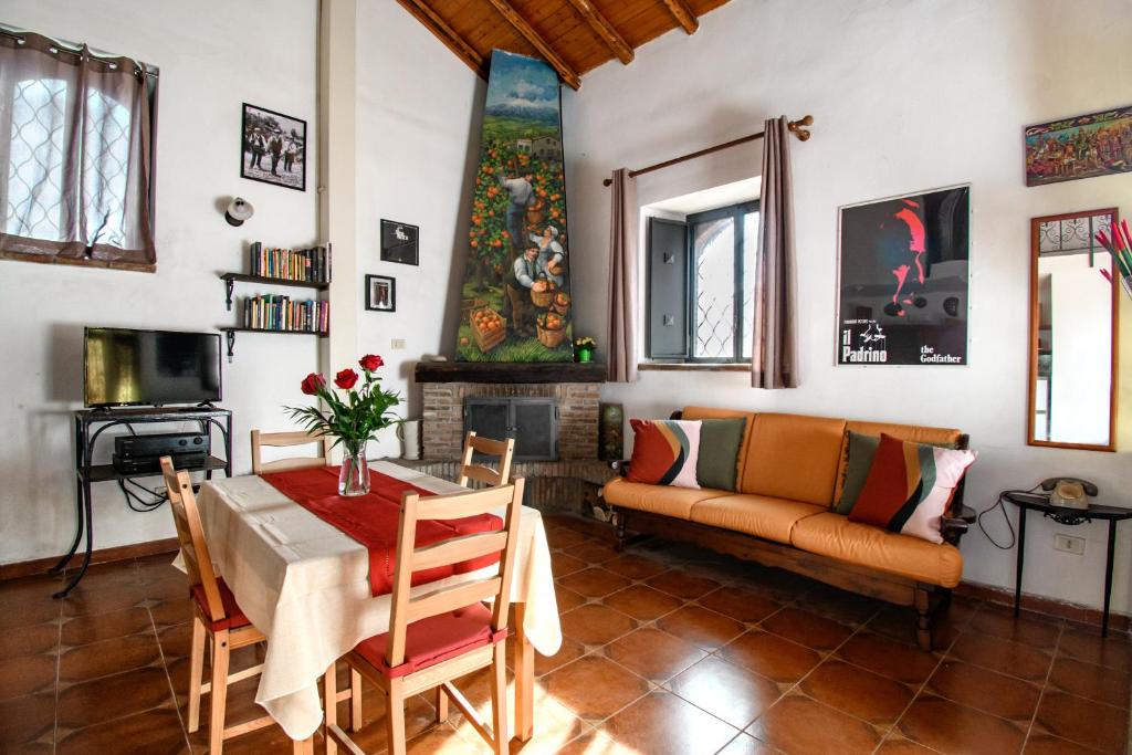 un soggiorno con un tavolo e un divano di Casa Don Vito ad Aci Bonaccorsi