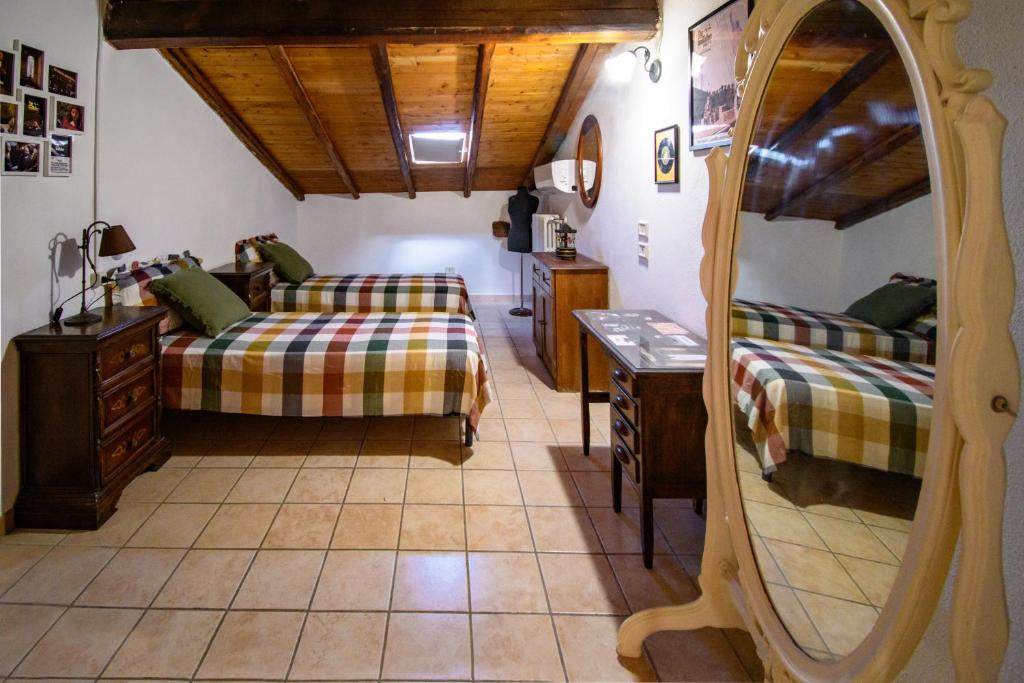 un soggiorno con 2 letti e uno specchio di Casa Don Vito ad Aci Bonaccorsi
