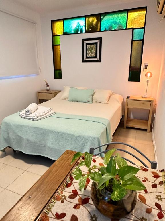 a room with two beds and a table and a stained glass window at Tiny Room Ingá in Colón