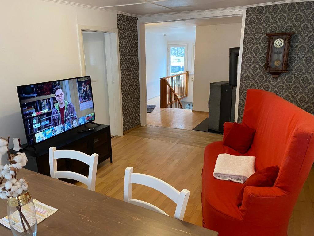 een woonkamer met een oranje bank en een televisie bij Self-check-in zentrale Fewos in Triberg - Nah am Wasserfall - in Triberg