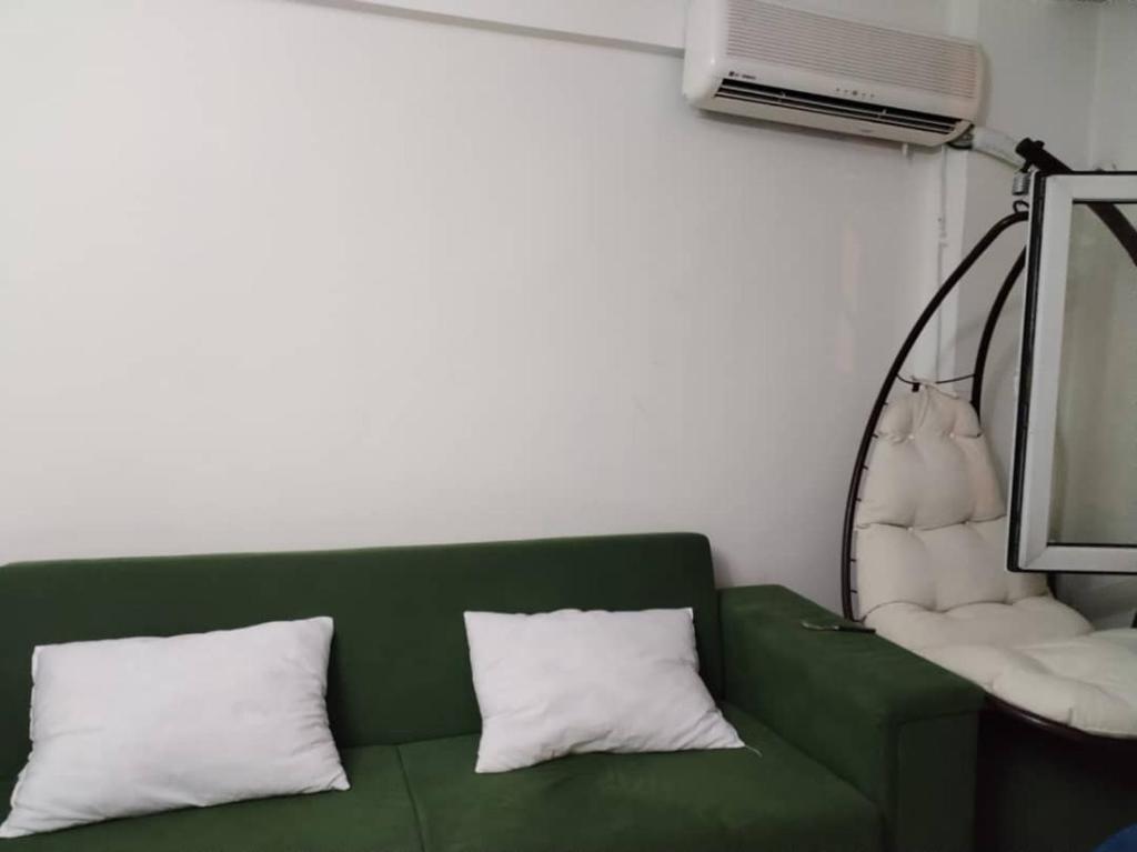 a green couch with two pillows and a lamp at Yola hime in Istanbul