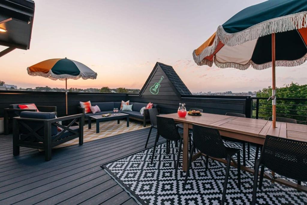 une terrasse avec une table, des chaises et des parasols dans l'établissement Designer Single Family House-Rooftop- Hot Tub, à Nashville