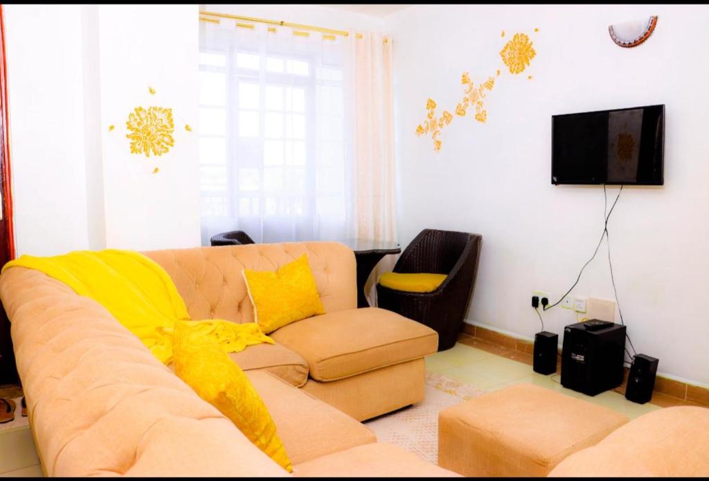 a living room with a couch and a television at Kay homes in Nairobi