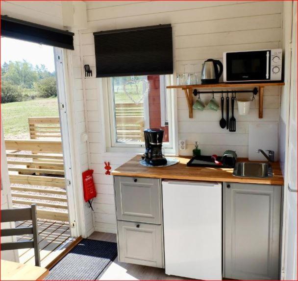 a small kitchen with a counter and a microwave at Lunagården in Åhus