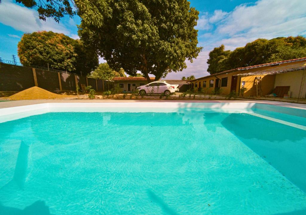 博阿維斯塔的住宿－Suíte Luxo Contêiner，一座大型蓝色游泳池,位于房子旁边