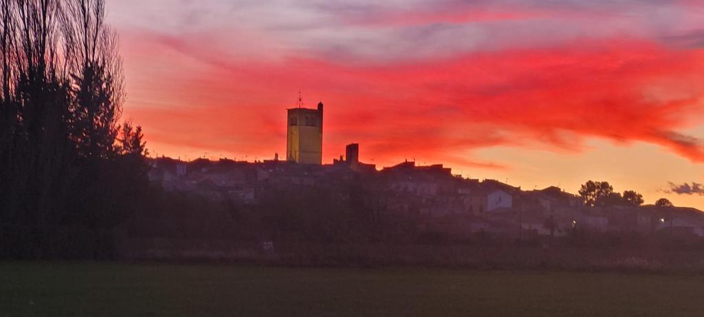 un bâtiment au sommet d'une ville avec un ciel rouge dans l'établissement Mitten im Dorf und doch im Grünen, à Montblanc
