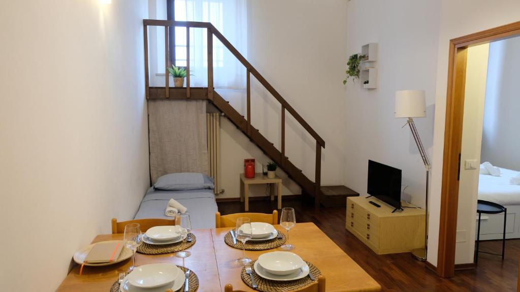 a dining room with a table and a staircase at Mazzini 81 - Ravenna Apartments in Ravenna