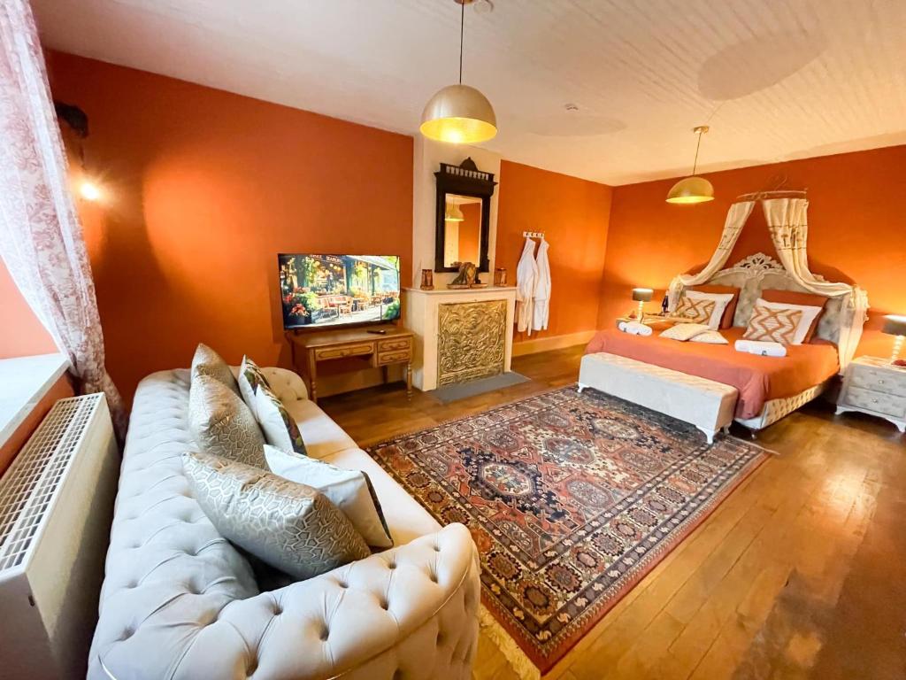 een woonkamer met een bank en een bed bij Chateau Bourgeoisie *** in Laimont