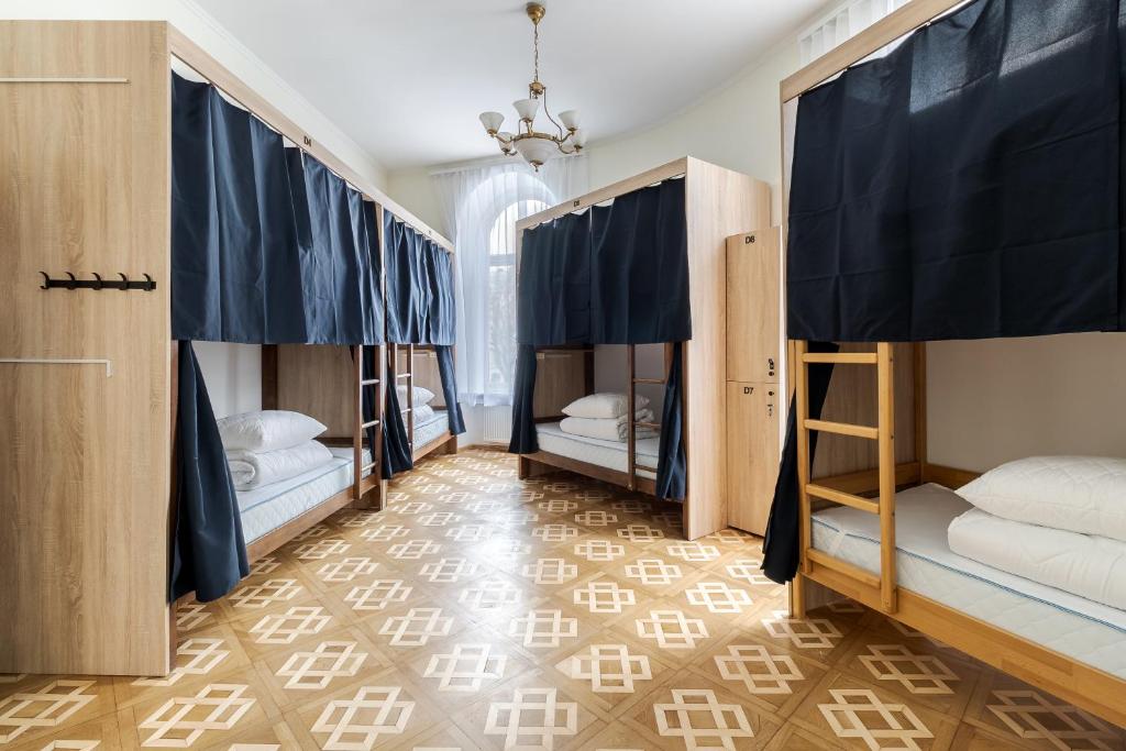 a room with four bunk beds in a room with a floor at Soborniy Hostel in Lviv