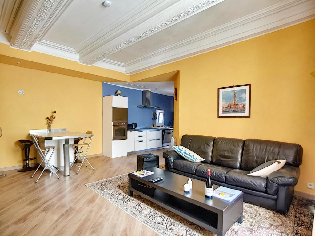 ein Wohnzimmer mit einem Sofa und einem Tisch in der Unterkunft Résidence Verdi - Appartements meublés en centre ville in Bédarieux