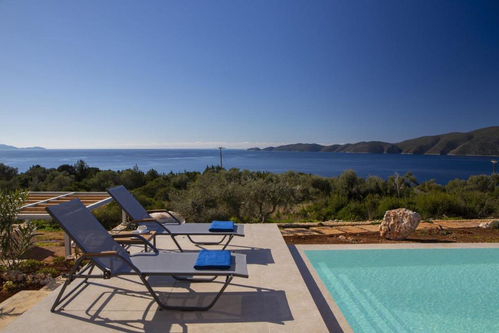 a couple of lounge chairs and a swimming pool at ELYANE VILLAS near AMMOUSSA BEACH in Évyiros