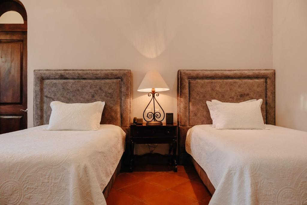 Postel nebo postele na pokoji v ubytování Hacienda Los Arcangeles