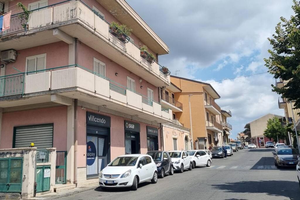 una fila de autos estacionados frente a un edificio en Ai piedi dell'Etna, en Belpasso